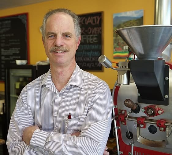 Robert W. Thurston beside a coffee roaster
